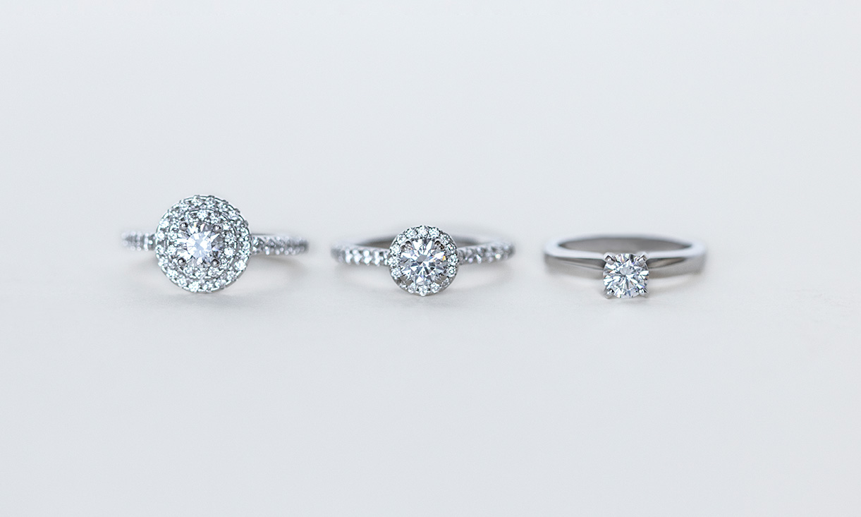 One double halo engagement ring, one halo engagement ring and a solitaire engagement ring.