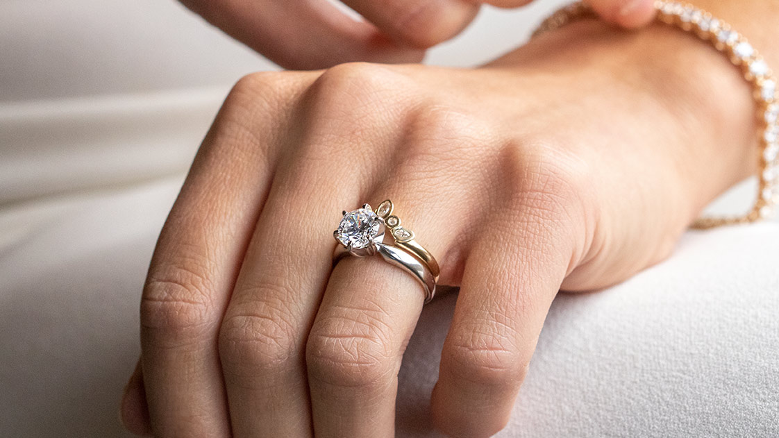 A close-up of a bride wearing a Diamond Nexus wedding ring set and tennis bracelet. 