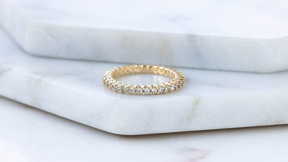 A yellow gold Diamond Nexus eternity band.