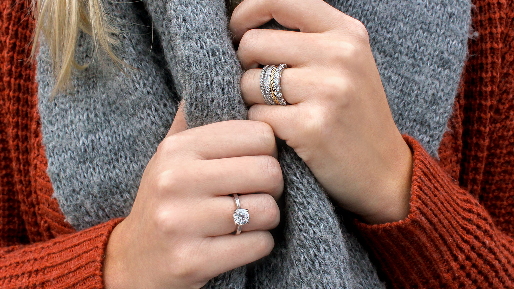 A women wearing a Diamond Nexus engagement ring on one hand and a mixed-metal band stack on her other.
