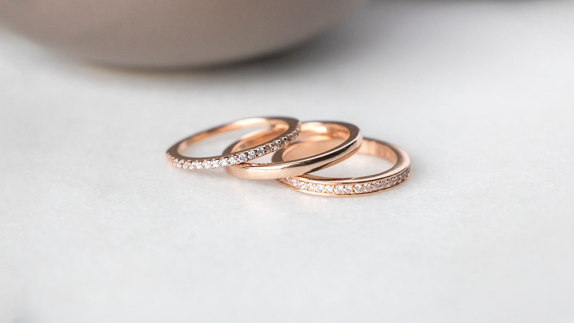 A rose gold ring stack featuring three Diamond Nexus bands.