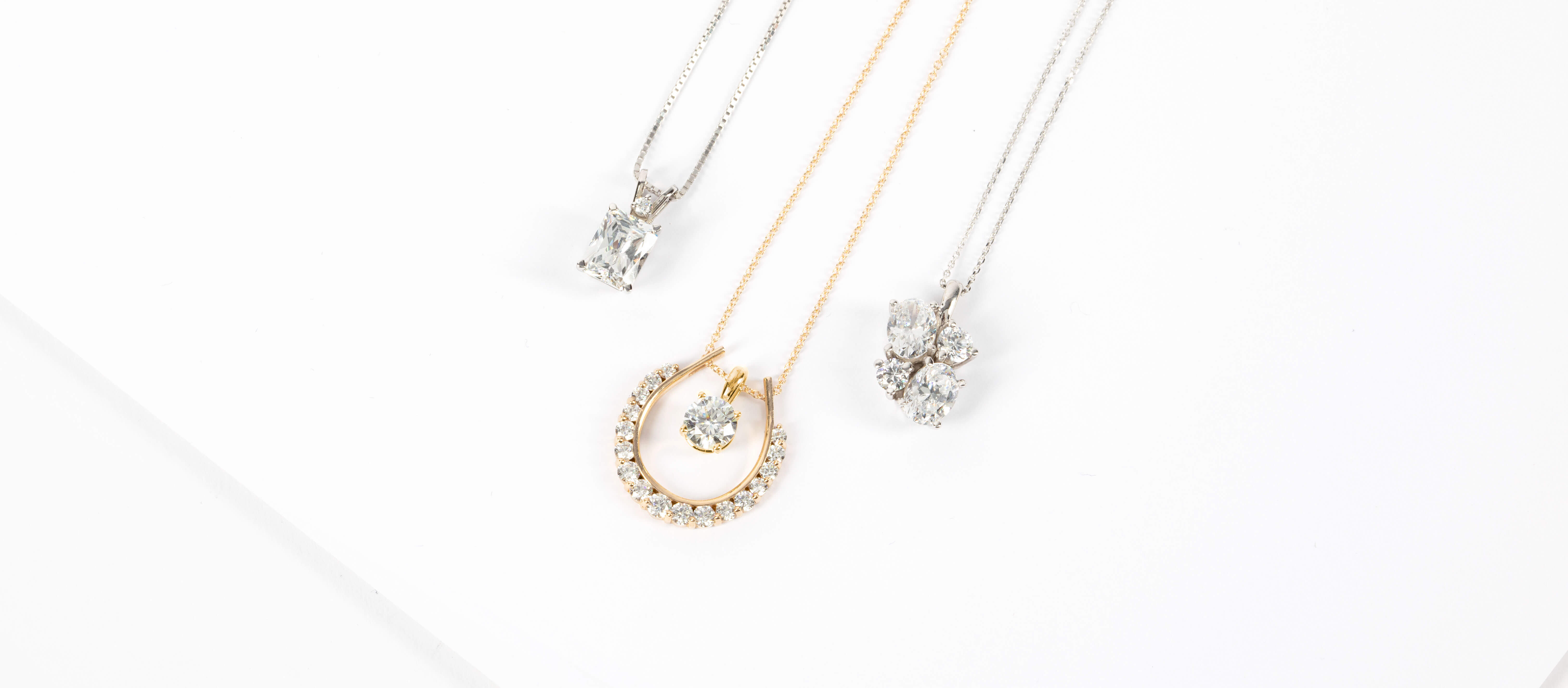 Assorted Diamond Nexus necklaces in white and yellow gold.
