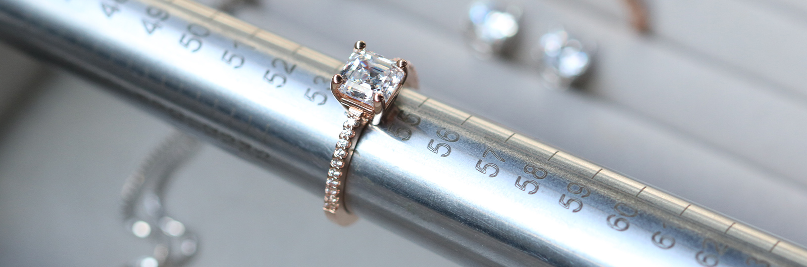 A lab created diamond simulant engagement ring being measured on a mandrel.