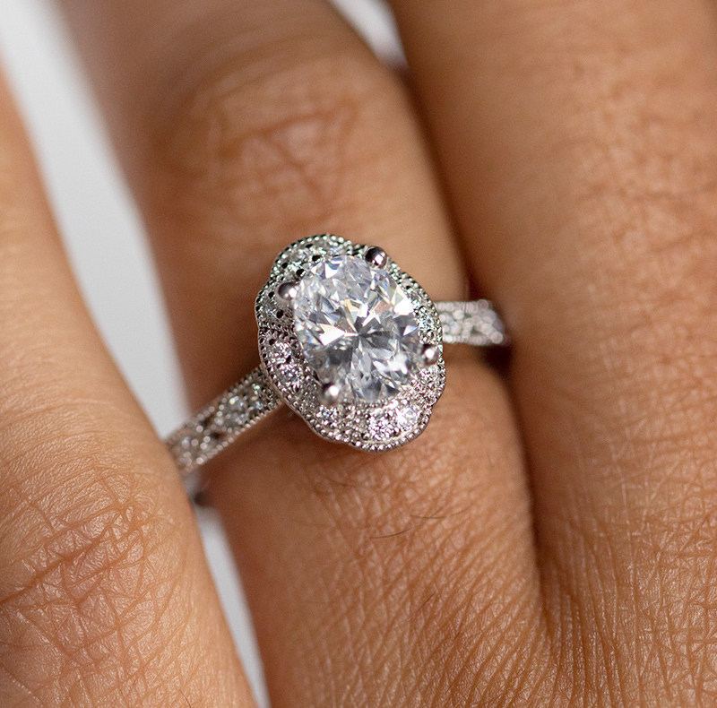 An oval cut stone in a vintage halo engagement ring setting