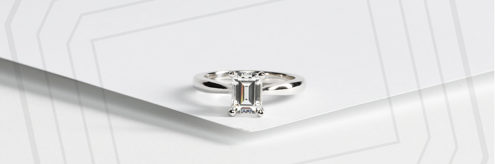 An emerald cut stone with a silver solitaire settings