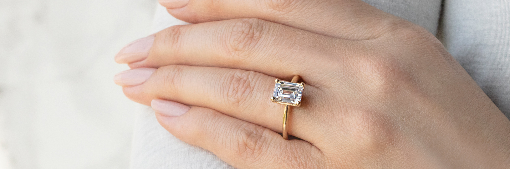 A solitaire setting with an emerald cut center stone
