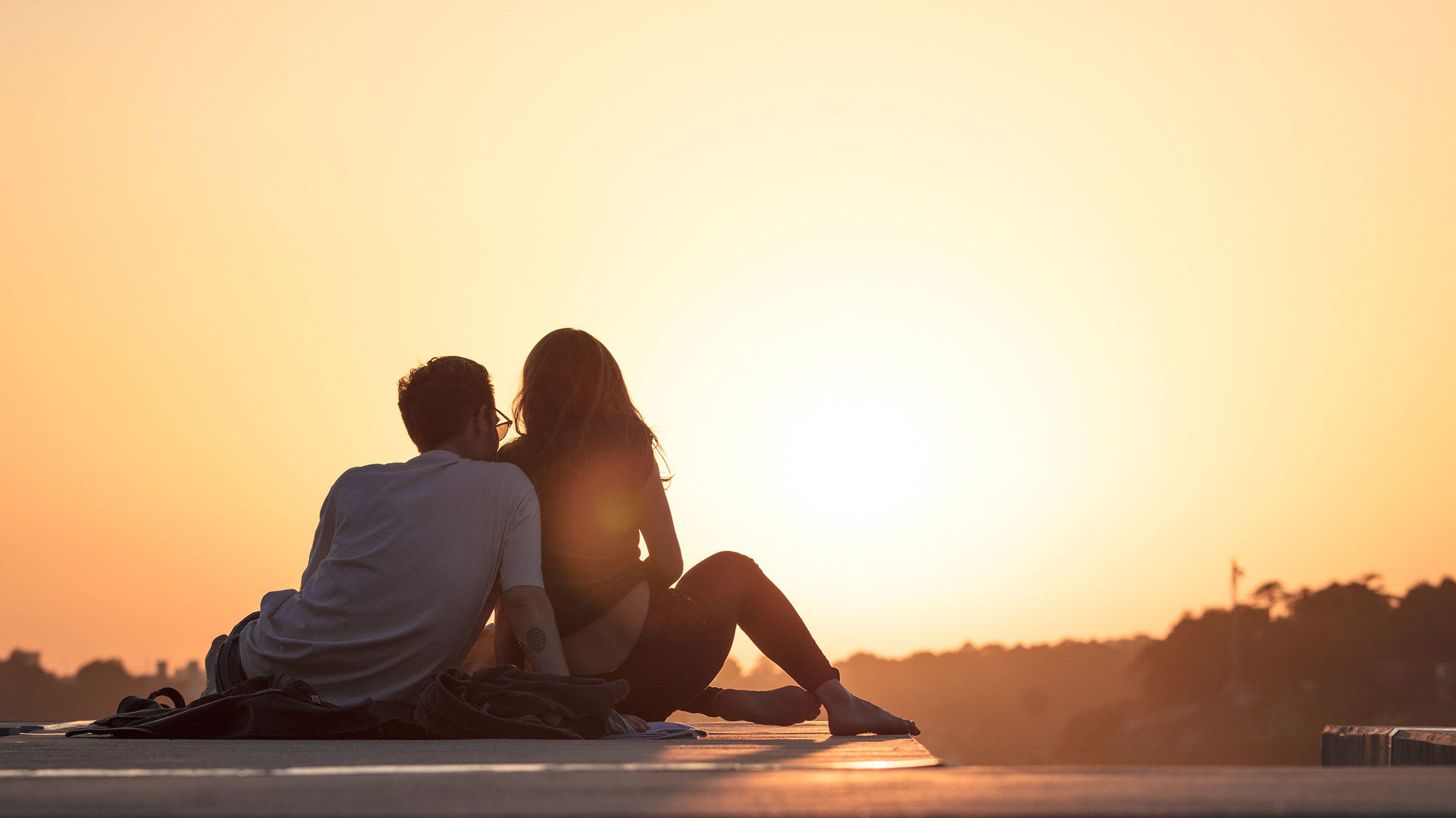 Couple sitting while viewing a romantic sunset