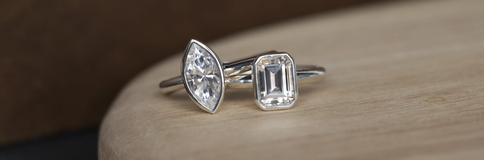 Two bezel set lab created diamond simulant engagement rings.