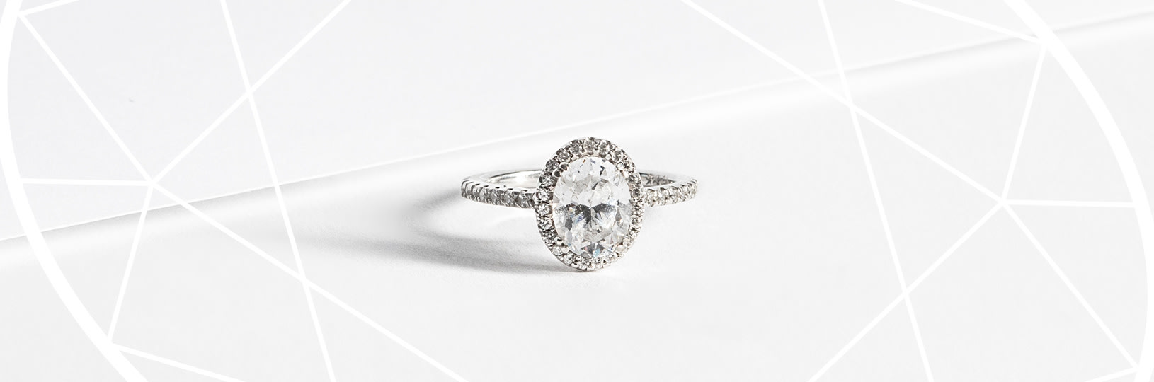 An oval cut stone in a halo engagement ring setting