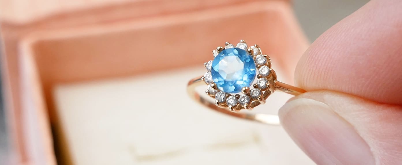 A halo engagement ring featuring a topaz stone