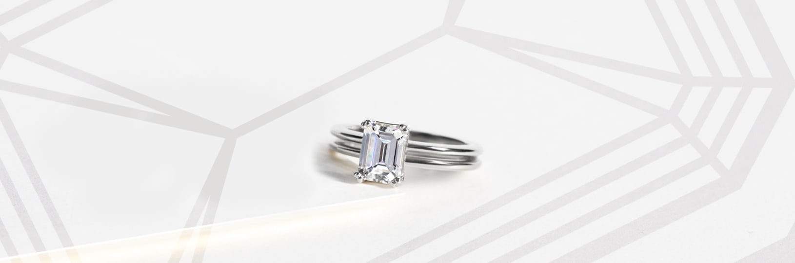 An engagement ring featuring an emerald cut center stone