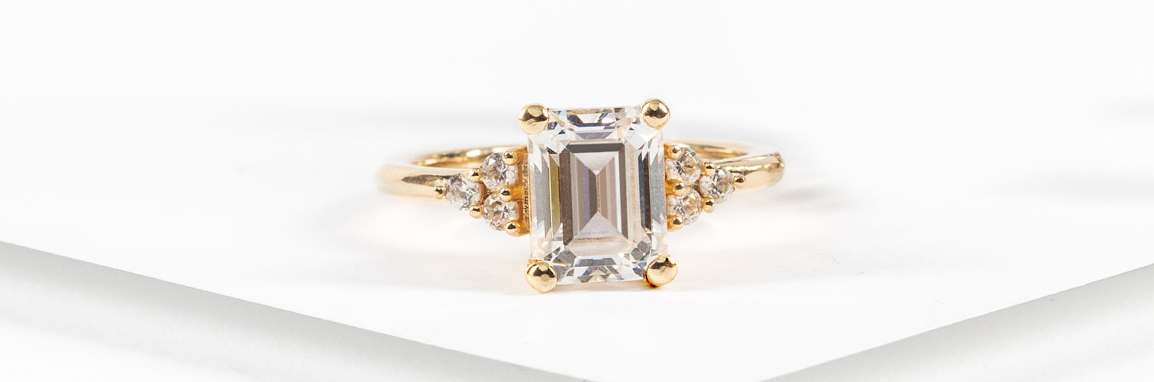 An emerald cut engagement ring in a three stone setting